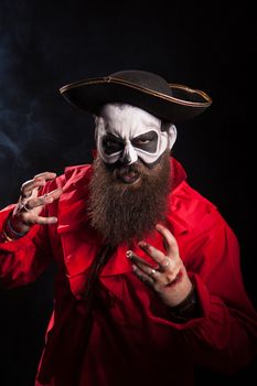 Actor with long beard and hat dressed up like a pirate over black background. Halloween costume.
