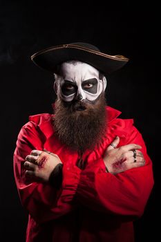 Scary bearded pirate with hands crossed over black background. Halloween disguiese