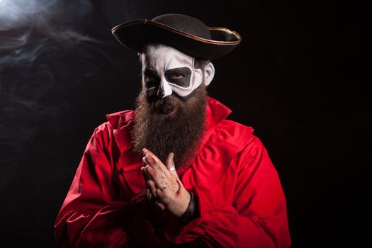 Man dressed up like a spooky medieval pirate over black background for halloween.