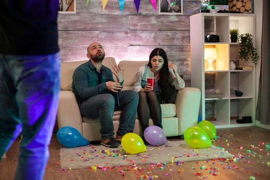 Young couple at a party after drinking too much beer having a fight.