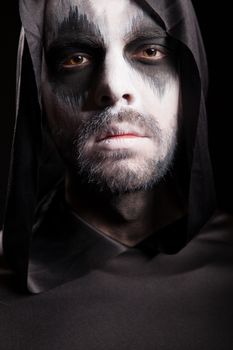 Close up portrait of grim reaper isolated over black background. Halloween costume.