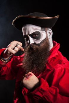 Medieval bearded man with pirate costume for halloween over black background.
