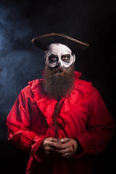 Actor wearing a pirate costume for halloween over black background.