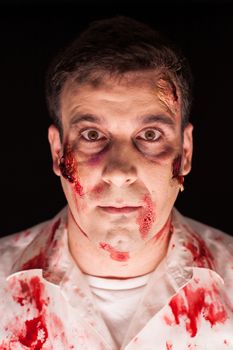 Close up of bloody zombie over black background for halloween. Creative makeup.