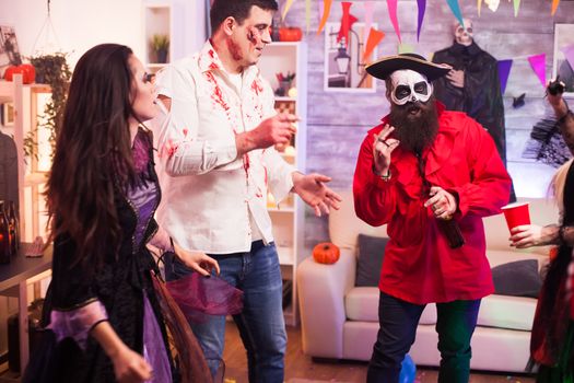 Man dressed up like a pirate with creative makeup celebrating halloween with his friends.