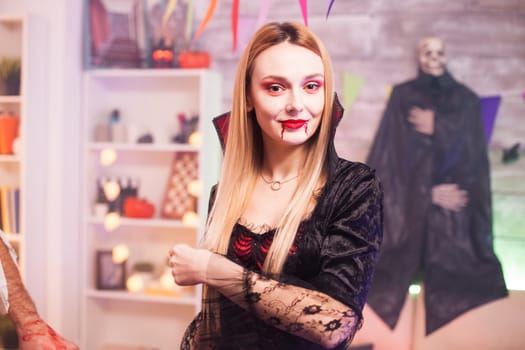 Portrait of beautiful woman dressed up like a vampire looking at the camera while celebrating halloween.