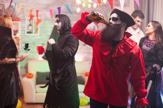Man dressed up like a medieval pirate drinking beer at halloween celebration.