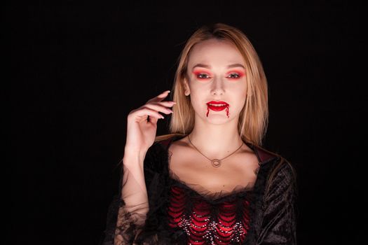 Seductive blond woman dressed up like a vampire for halloween.
