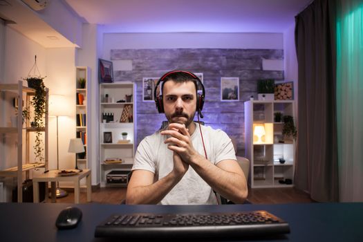 Pov of young man clapping after his victory while playing online shooter games.