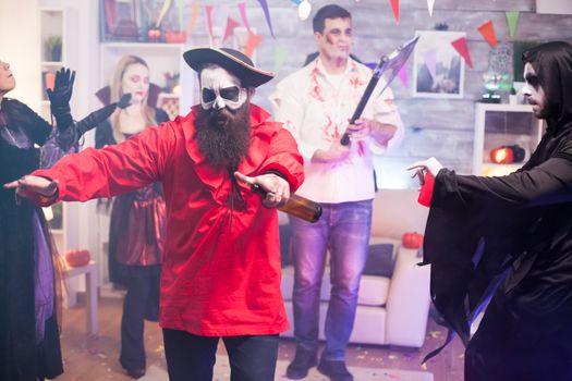 Man dressed up like drunk medieval pirate at halloween party with group of people.