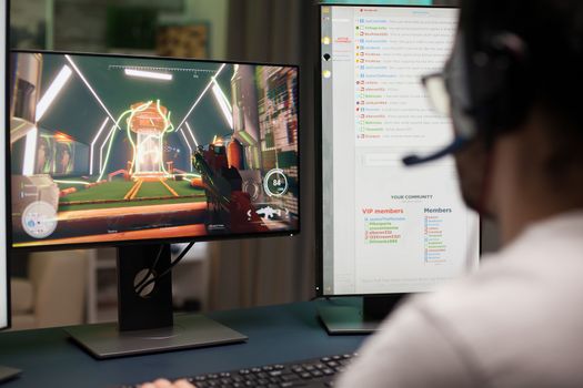 Young man with eyeglasses playing video games at home and streaming it.