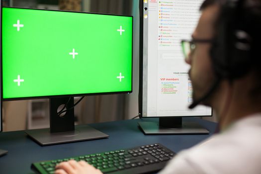 Close up young man playing games on computer with green screen.