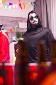 Scary man dressed up like a grim reaper at halloween celebration.
