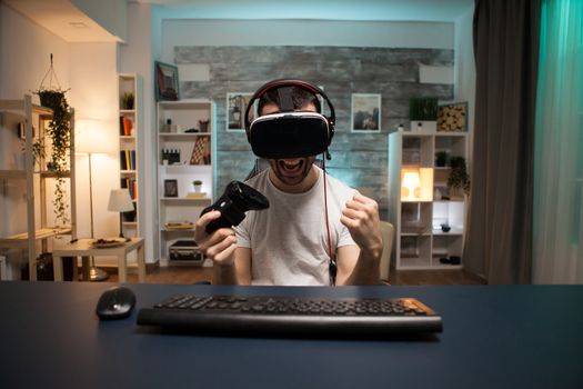 Pov of excited young man about his victory on online game wearing virtual reality goggles.
