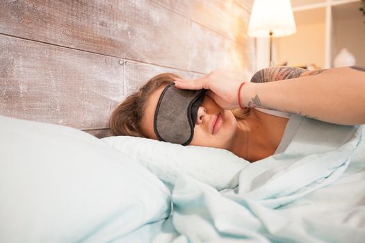 Beautiful young woman taking a nap with her eye cover masks.