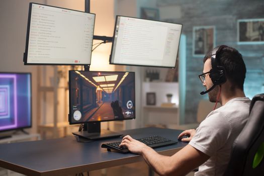 Young man with eyeglasses relaxing playing shooter games at home on stream.