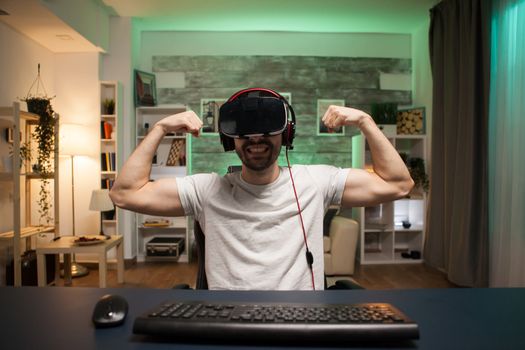 Pov of professional gamer flexing his muscle celebrating his victory on online shooter game.