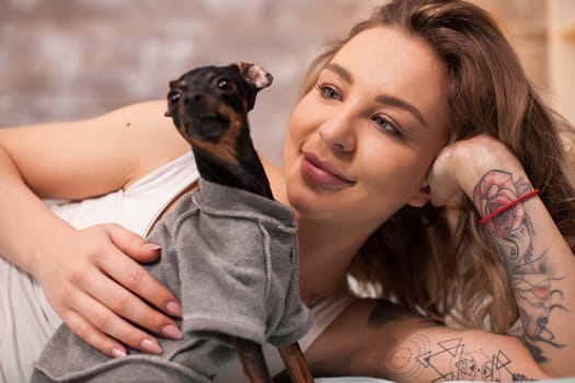 Beautiful young woman in pajamas playing with her dog in the middle of the night.