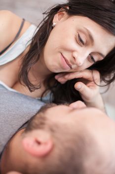 Playful caucasian couple looking at each other in the morning after waking up.