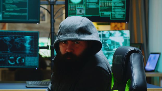 Dangerous hacker wearing a hoodies and looking into the camera. Cyber criminal.