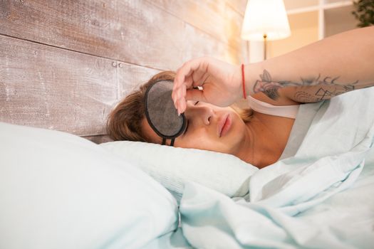 Beautiful young woman pulling her mask cover over the eyes.