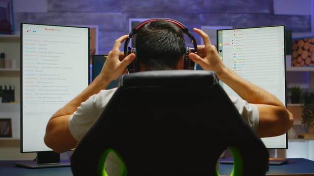 Young man preparing for an online shooter game session. Concentrated player coming at his desk