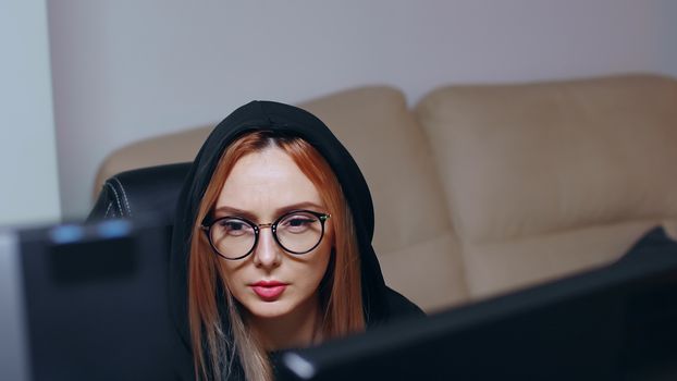 Revealing shot of wanted female hacker using super computer to write a malicious virus.