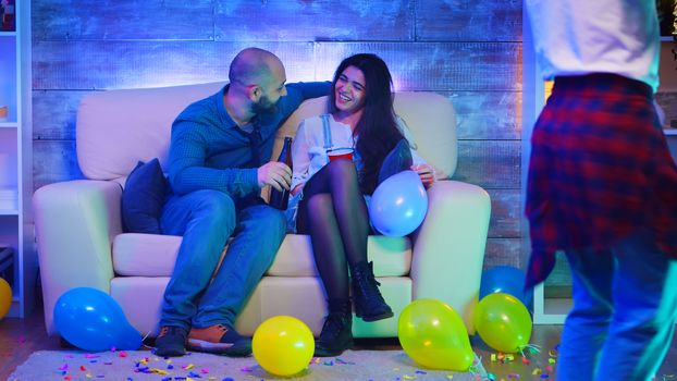 Handsome young man socializing with a beautiful girl at his friends party.