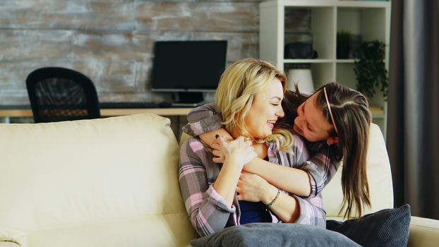 Cheerful little daughter hugging her mother. Mother and daughter relationship.