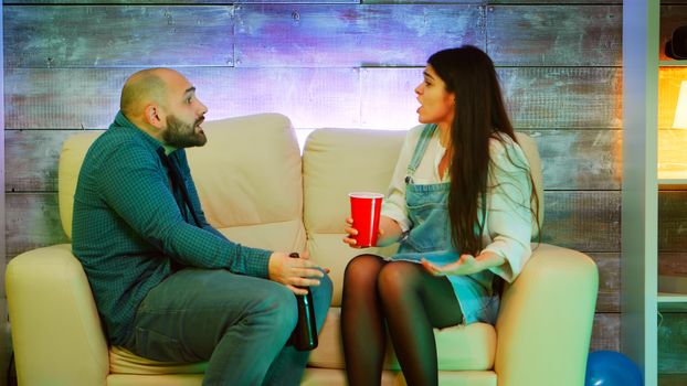 Best friends having a conflict at a college party in a room with neon lights.