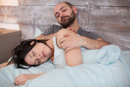 Beautiful wife in pajamas sleeping on her husband lap in the morning.