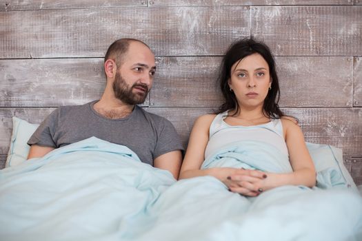 Wife in pajamas with emotional problem ignoring her husband.