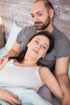 Top view of happy married couple in the morning after waking up.