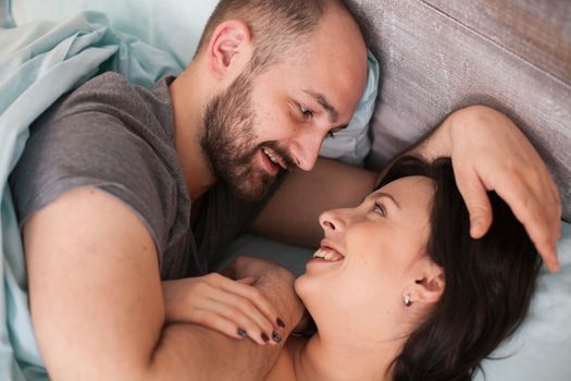 Beautiful loving couple in the morning wearing pajamas. Wife smiling.