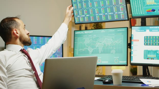 Stock market trader drinking coffee while checking the economy decline on laptop.