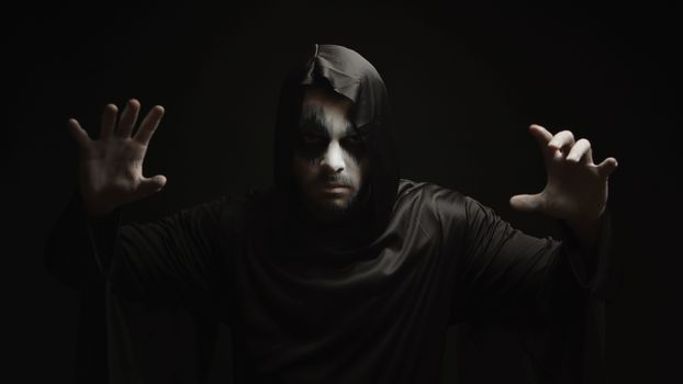 Dangerous hell demon doing magic over black background. Halloween costume and design