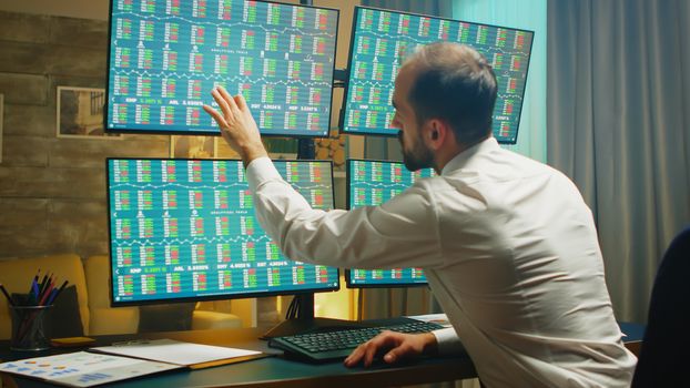 Financial consultant checking the exchange market on computer with multiple monitors. Economy crash.