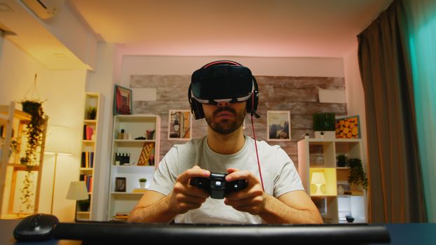Pov of professional gamer wearing virtual reality headset using wireless controller.