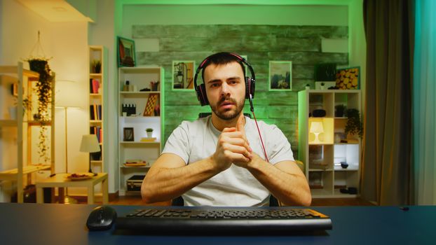 Pov of young man putting his headphones and start playing online shooter game.