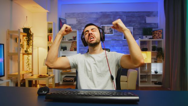 Young professional game player screaming with hands raised after his victory