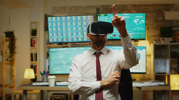 Male stock market trader using virtual reality in home office.