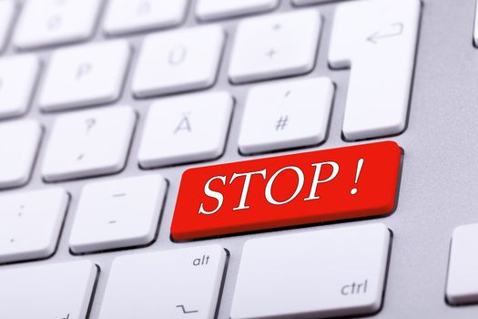 Aluminium keyboard with STOP word in red. Studio photo. Standard keyboard in close up shooting with blurred background. Alert