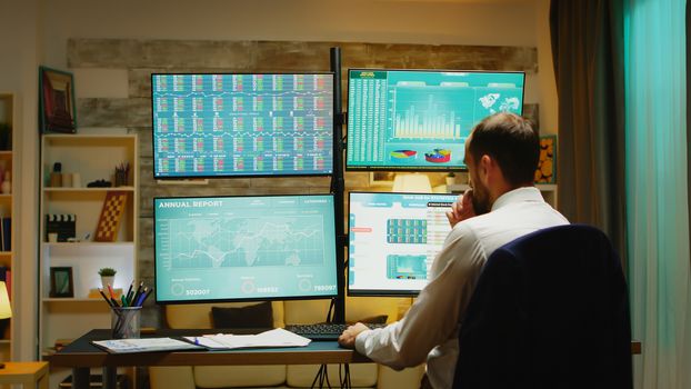 Businessman in suit arriving home checking if the stock market is crashing.