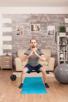 Fit man training his legs on yoga mat during global pandemic.