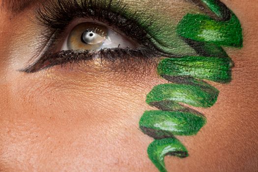 Close up of an eye with green artistic make up in studio photo