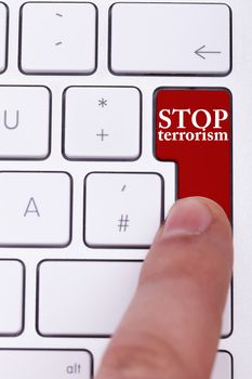 Finger pressing on stop terrorism button on keyboard. Stop the crimes against civil people