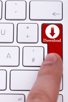 Finger pressing the red download button on keyboard. Torrent and p2p. Digital data transfer