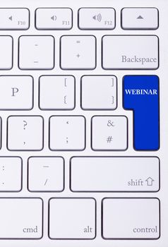 Keyboard with webinar text on blue button in close up