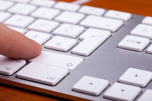 Finger pressing on keyboard key in close up