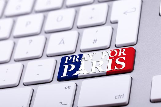 Keyboard with pray for paris text on national France flag. International support for france against terrorist atack from Paris